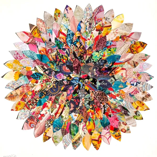 a bunch of petal shapes cut out of Johnny Was catalogues, arranged in concentric overlapping circles to create a floral design.